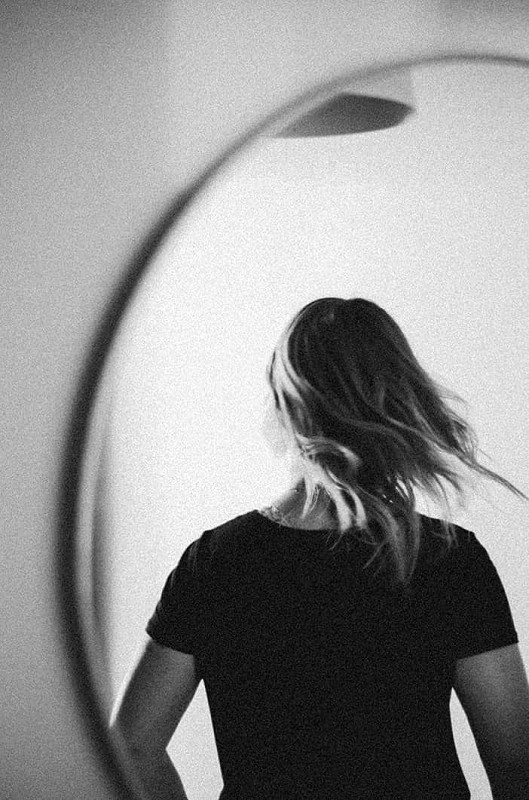 The back of a woman’s head as seen through a mirror